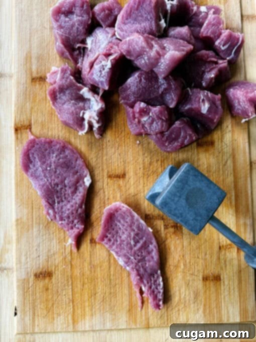 Tenderizing the pork tenderloin medallions with a meat mallet