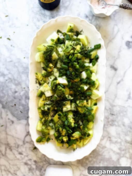 Vibrant fresh herbs and thinly sliced scallions are generously sprinkled over the cucumber and avocado base of the feta salad.