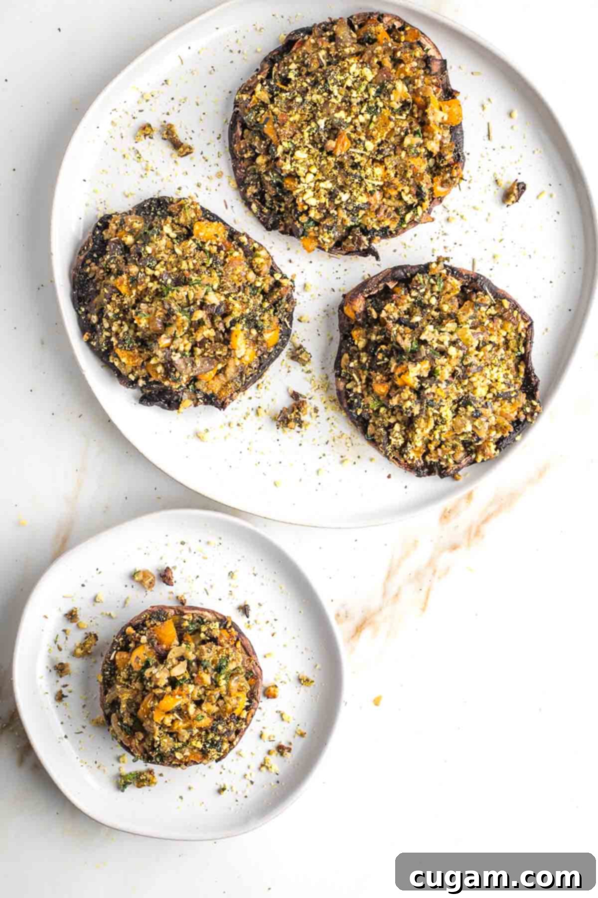 Plate with three large stuffed portobello mushrooms and one on an individual plate. 