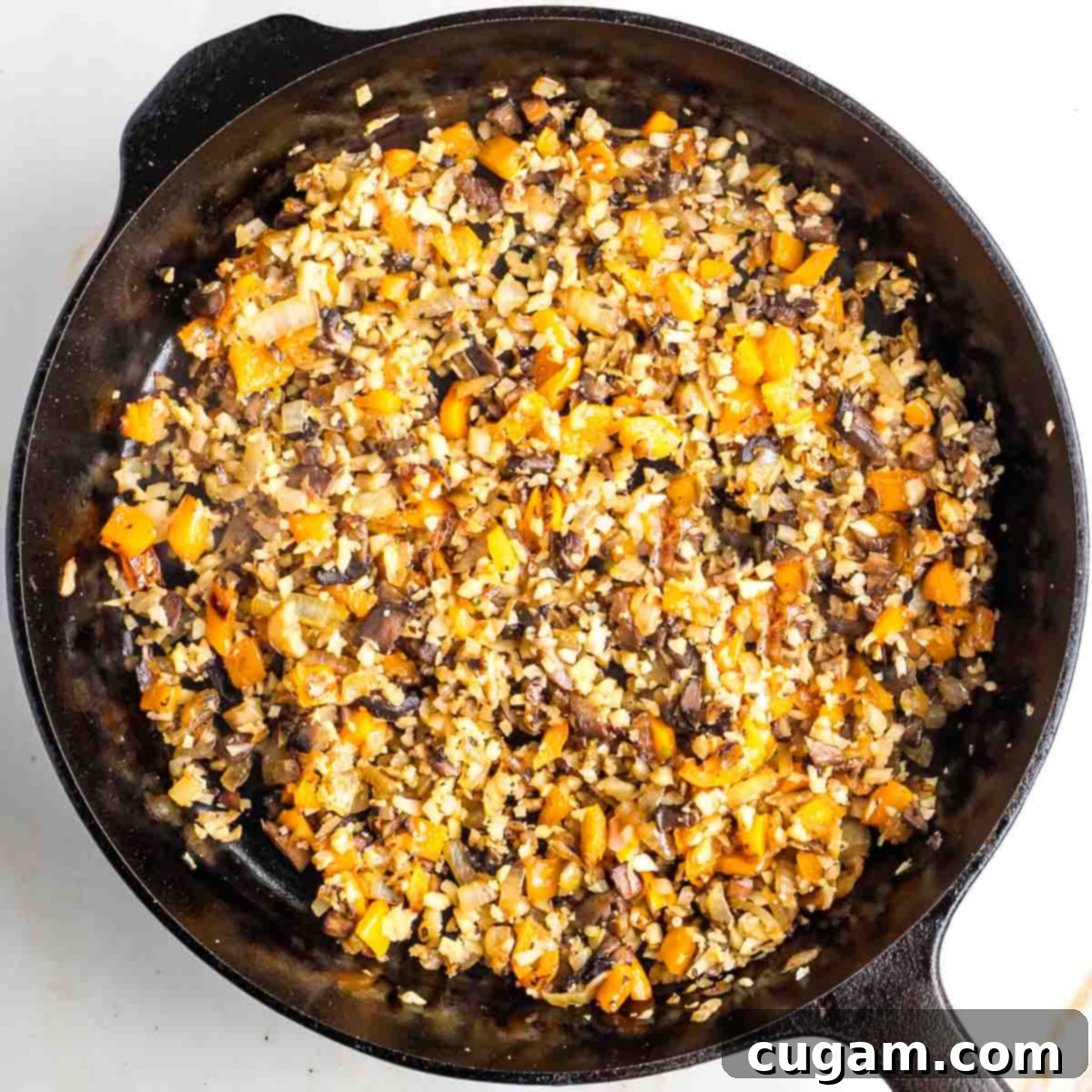 Diced vegetables in a cast iron skillet.