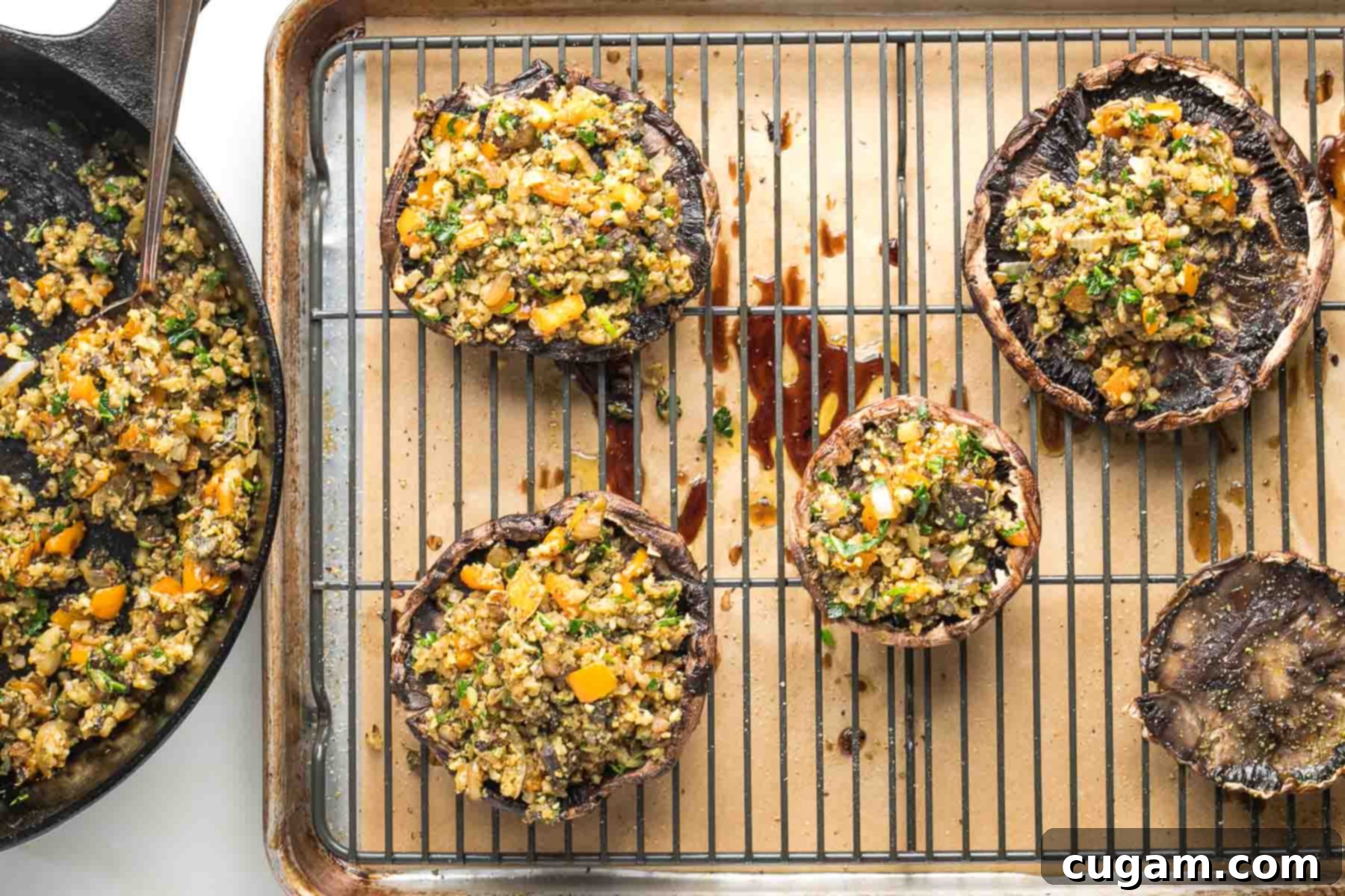 Mushroom caps stuffed with veggie filling on a wire rack in a baking tray.