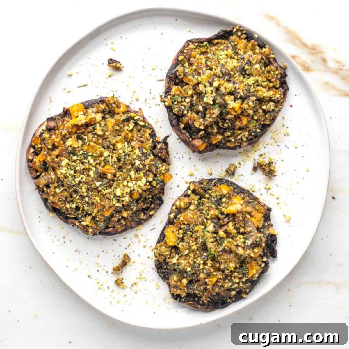 Two stuffed portobello mushrooms in a glass airtight container.