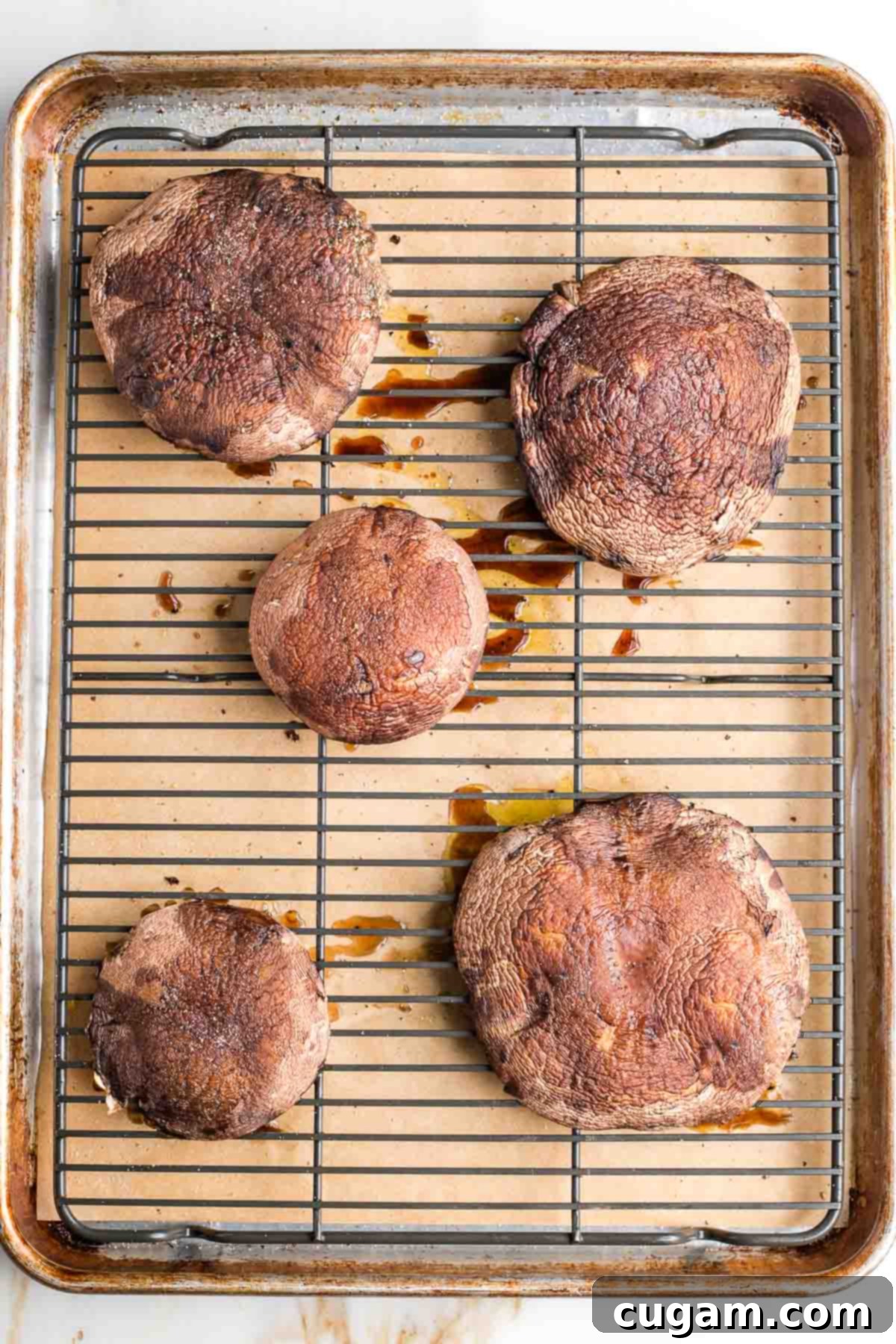 Large portobello mushroom caps on a wire rack on a baking tray. 