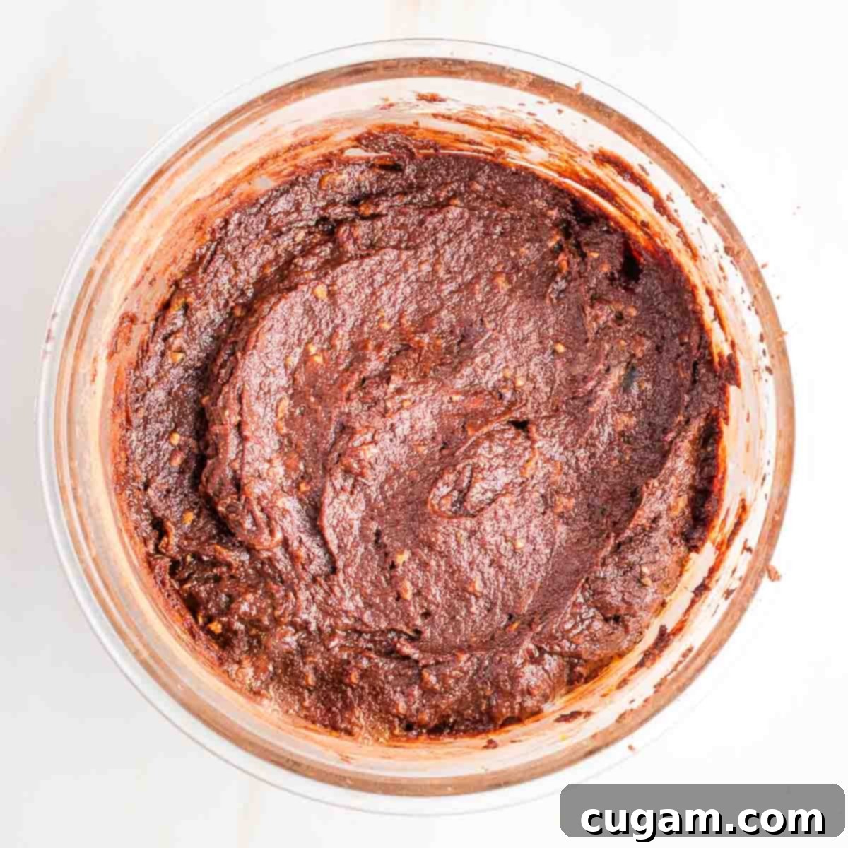 Chocolate brownie batter in a large glass bowl. 