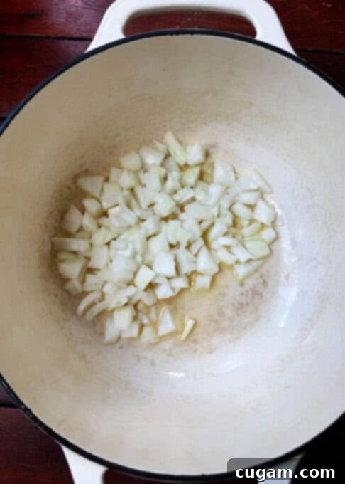 Chopped onions cooking in melted butter in a large pot