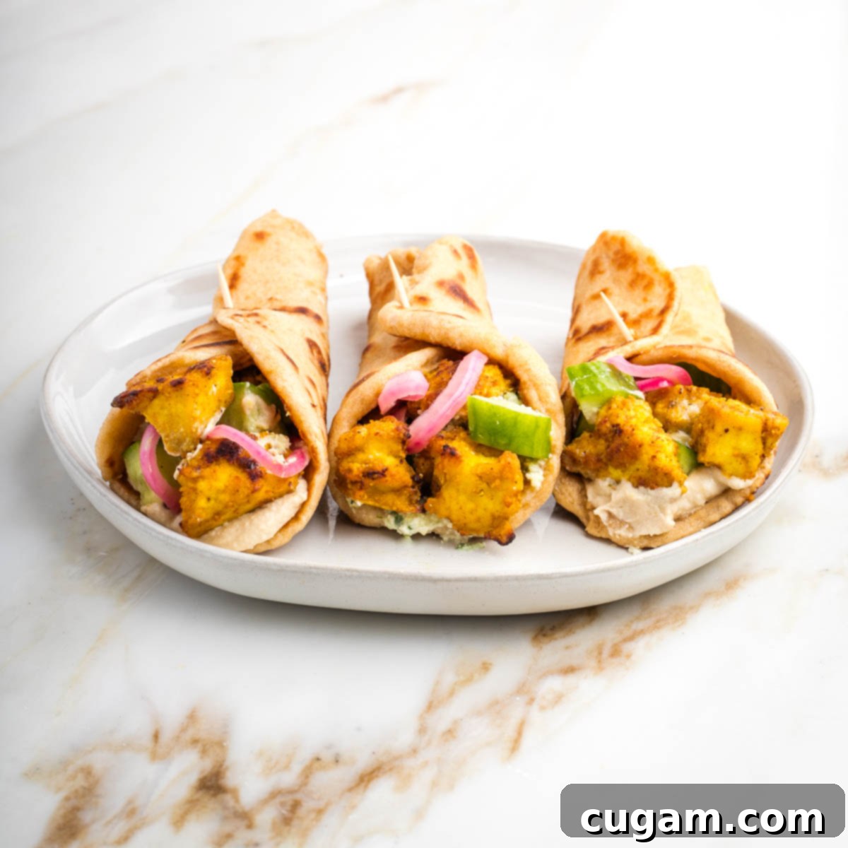 Tofu shawarma bowl with lettuce, falafel, pickled onions, cucumber, hummus.