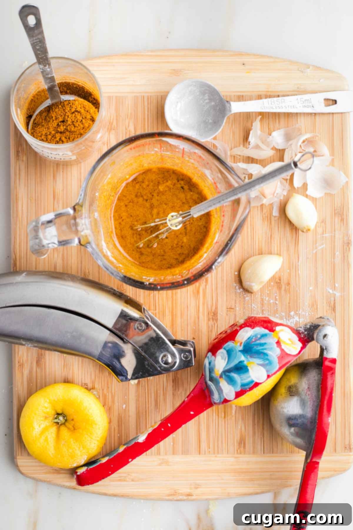 Bowl with all the marinade ingredients: olive oil, lemon juice, shawarma spice, arrowroot powder, minced garlic.