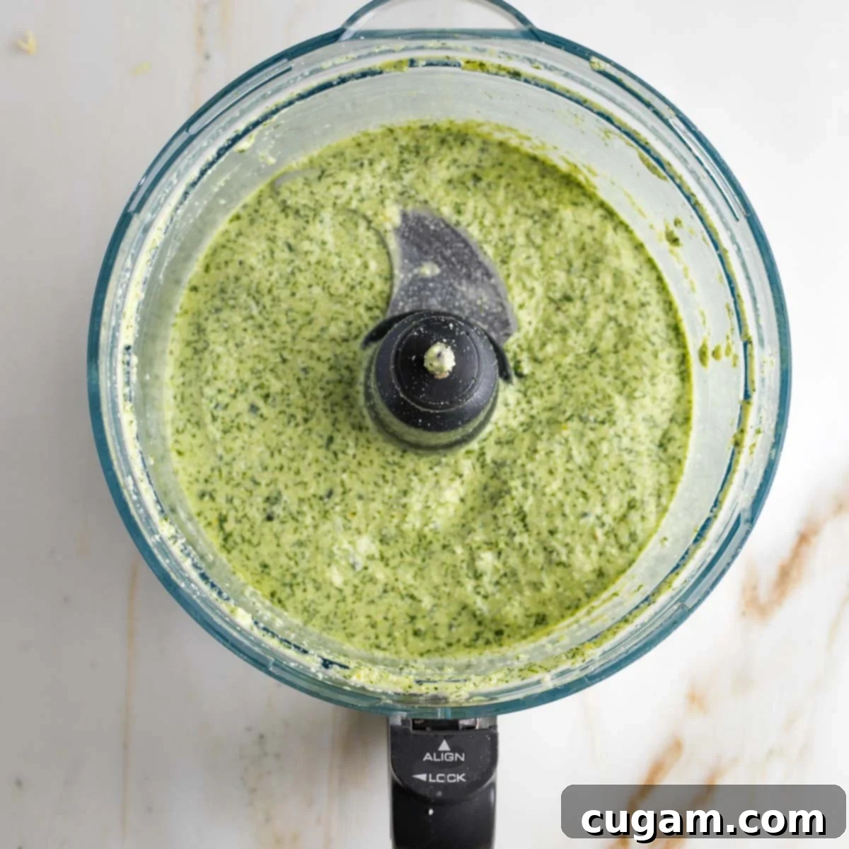 Food processor bowl with green creamy vegan tzatziki sauce. 