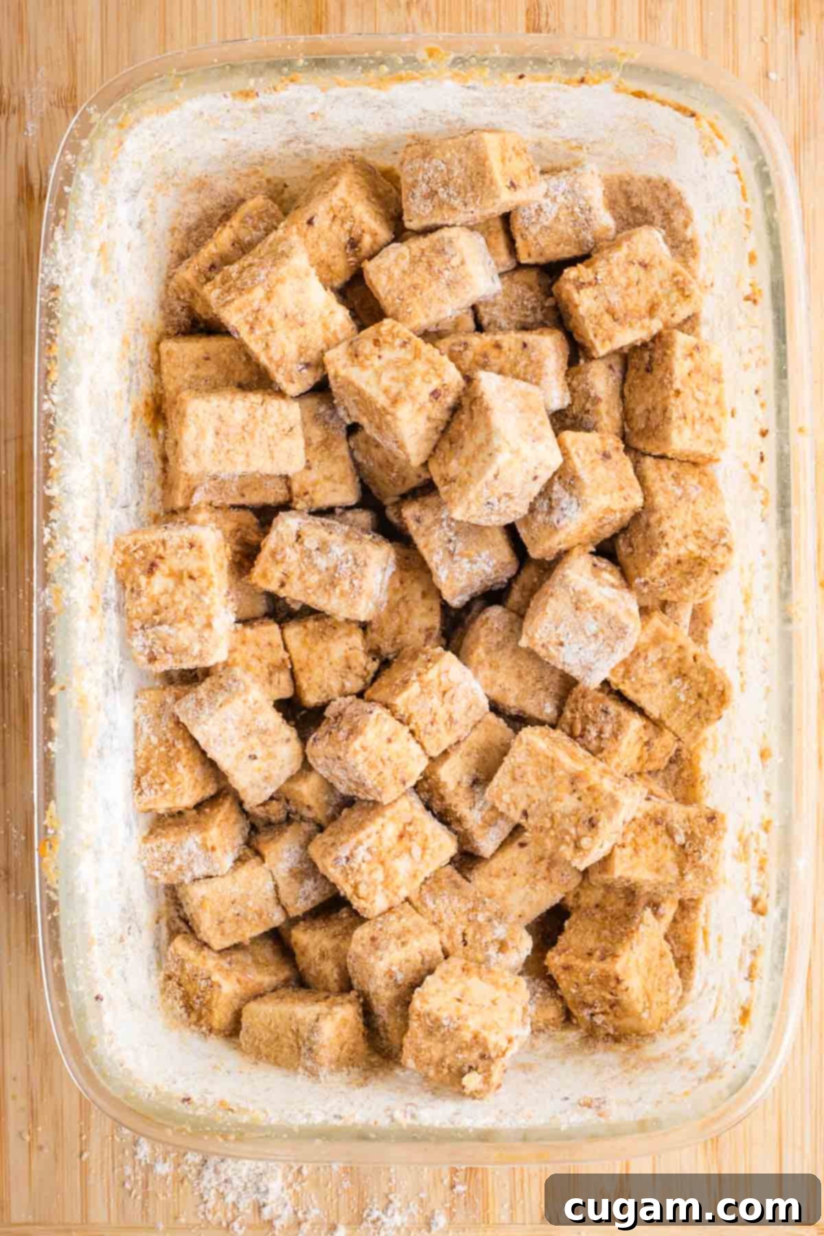 Coated tofu cubes in a glass dish.