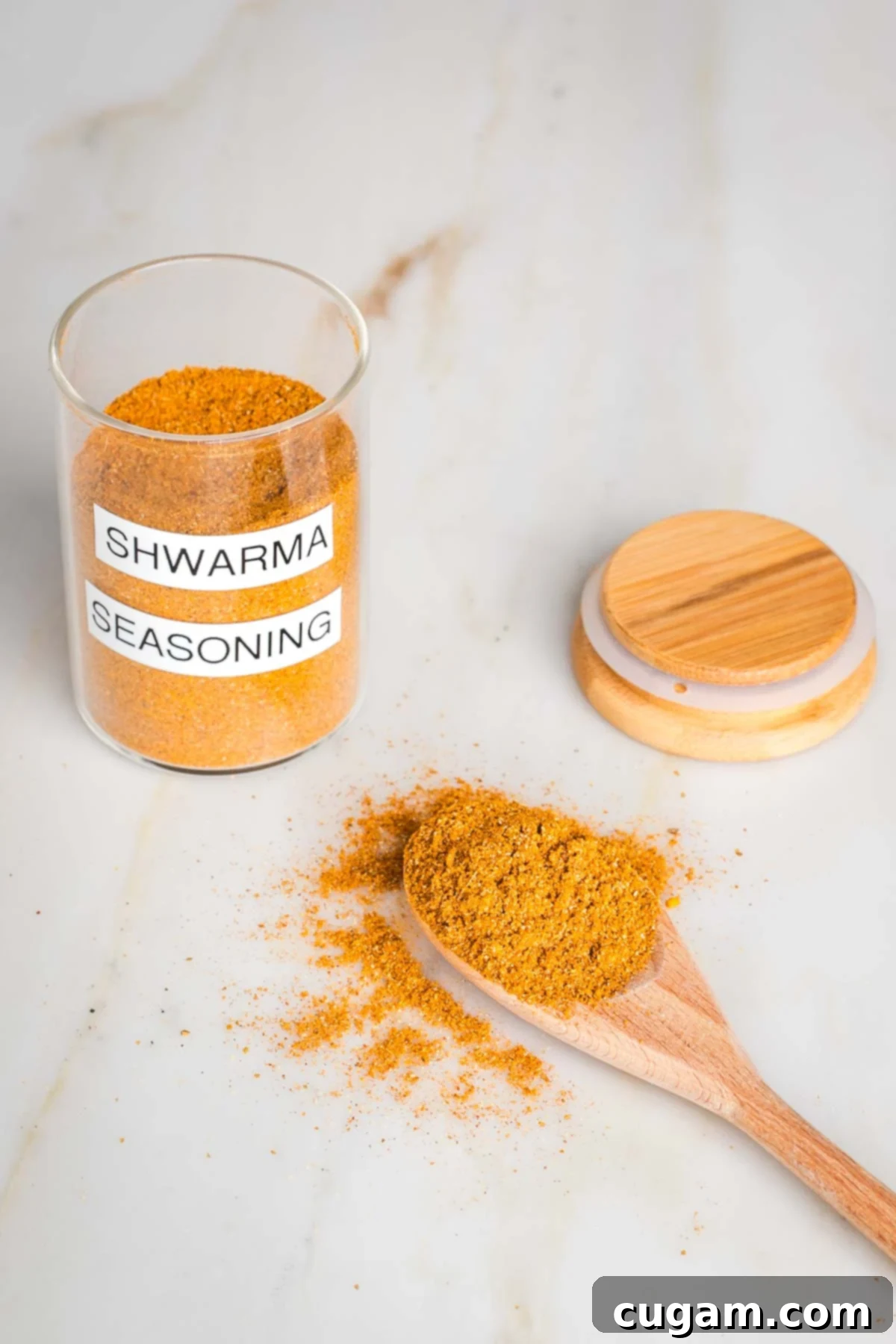 Craft Your Own Shawarma Seasoning 2 Jar labeled "shawarma spice blend" filled with orangish brown powder, a spoon filled with it and the lid to the jar.