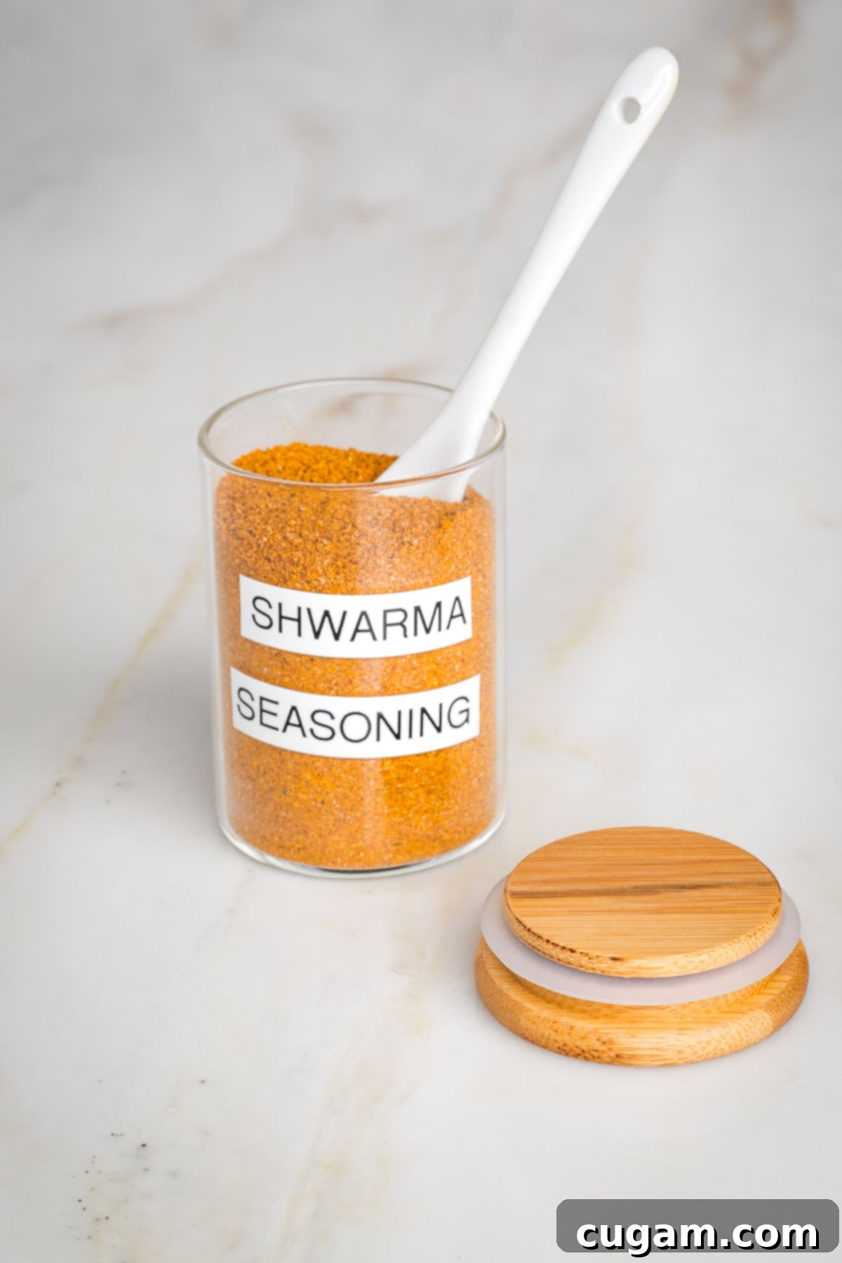 Craft Your Own Shawarma Seasoning 4 Small glass jar labeled "shawarma seasoning" with a spoon inside and the lid off to the side.