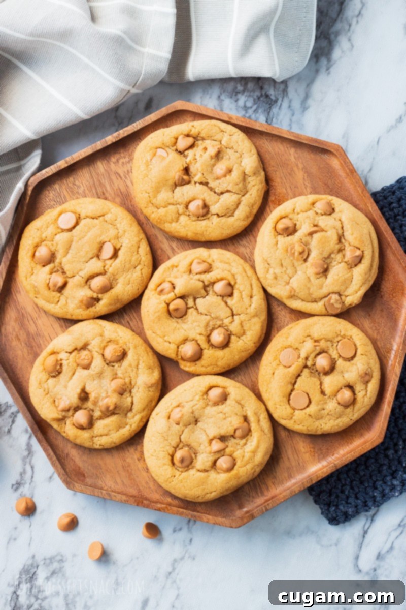 Butterscotch Chip Cookies are chewy, and have butterscotch pudding mix and butterscotch chips in them to add all that lovely caramel flavor. seven butterscotch chip cookies on a wooden octagon plate