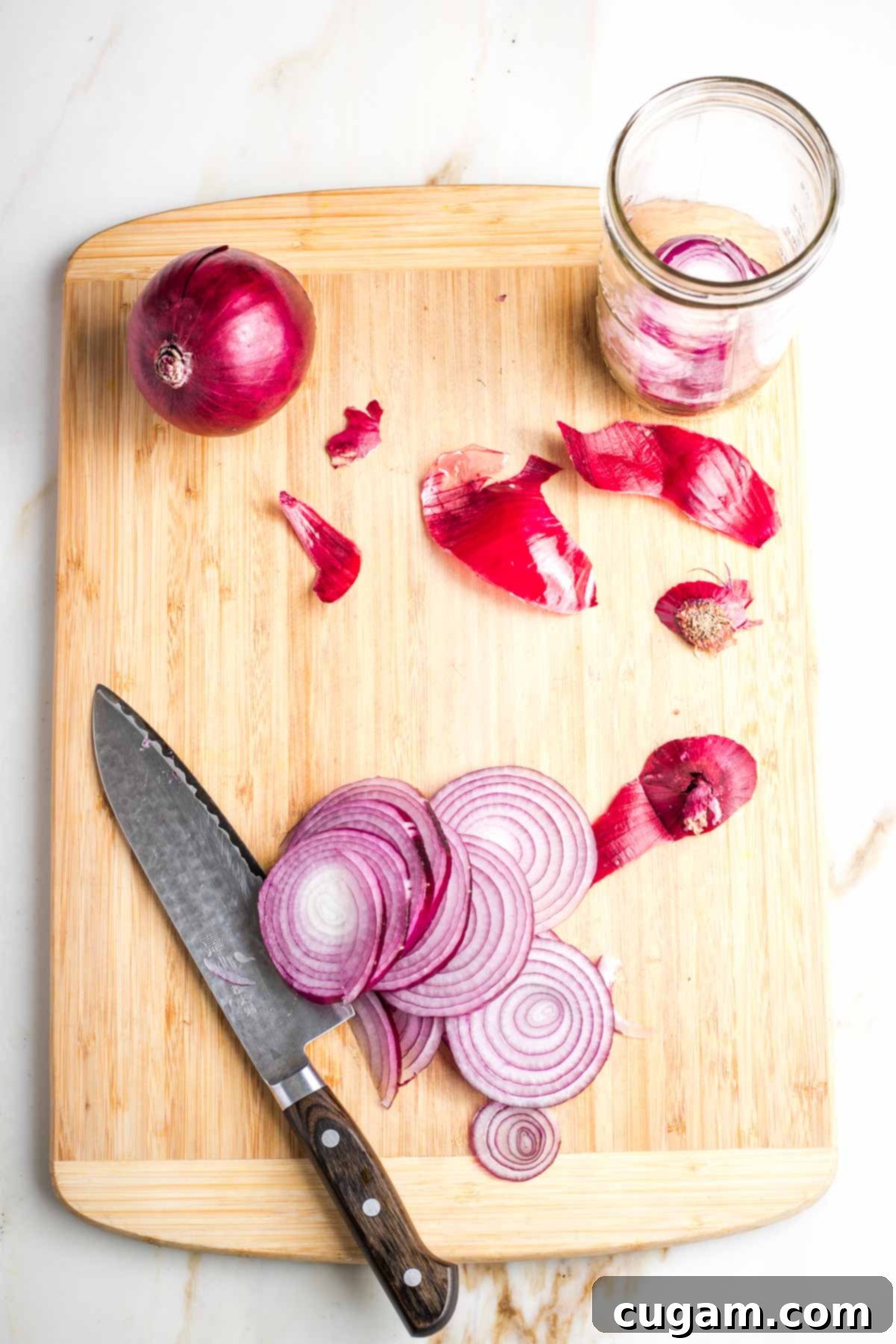Trimming and slicing red onions on a cutting board.