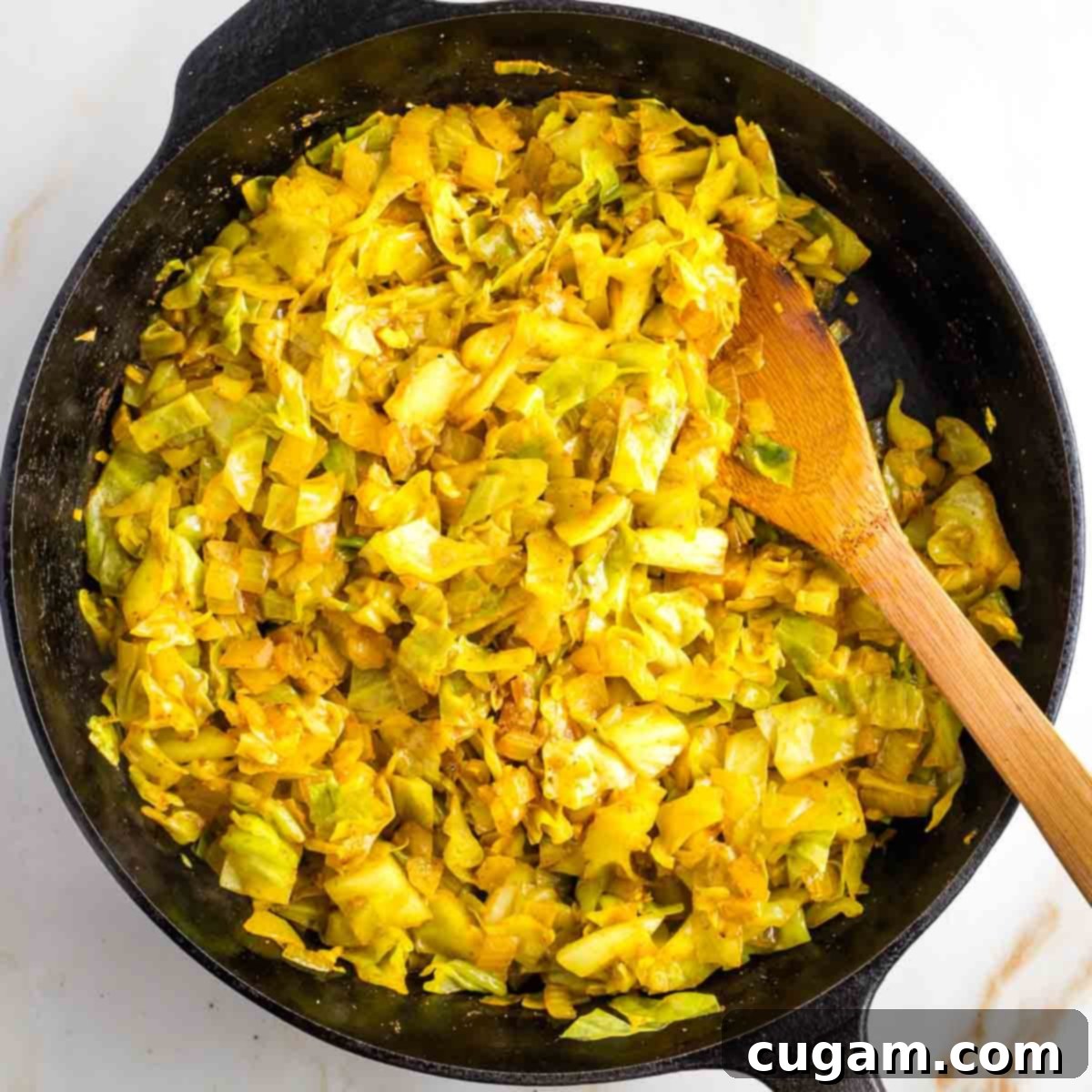 Cabbage simmering in a skillet with water.