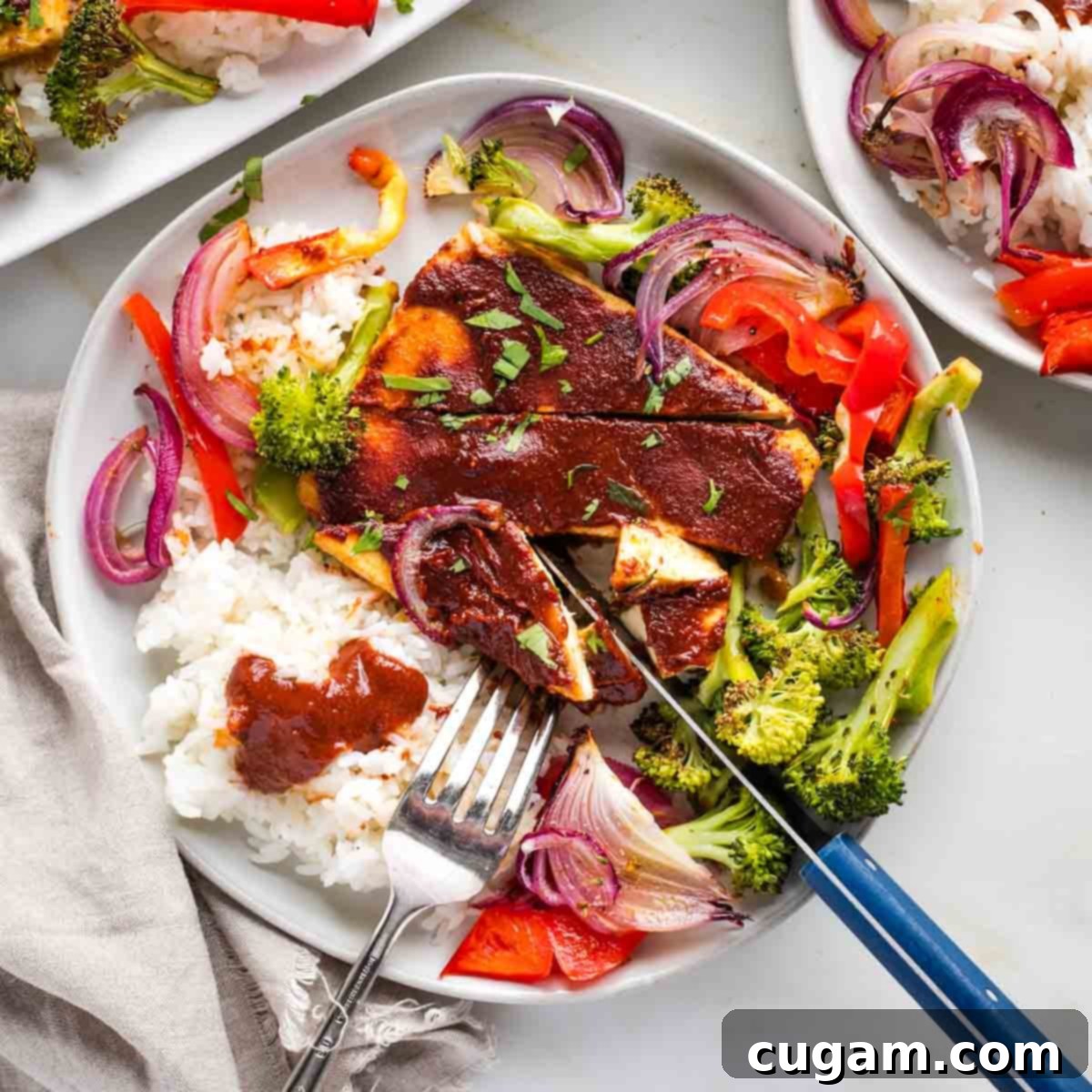 Plate filled with tofu steaks with bbq sauce, rice, and roasted veggies.