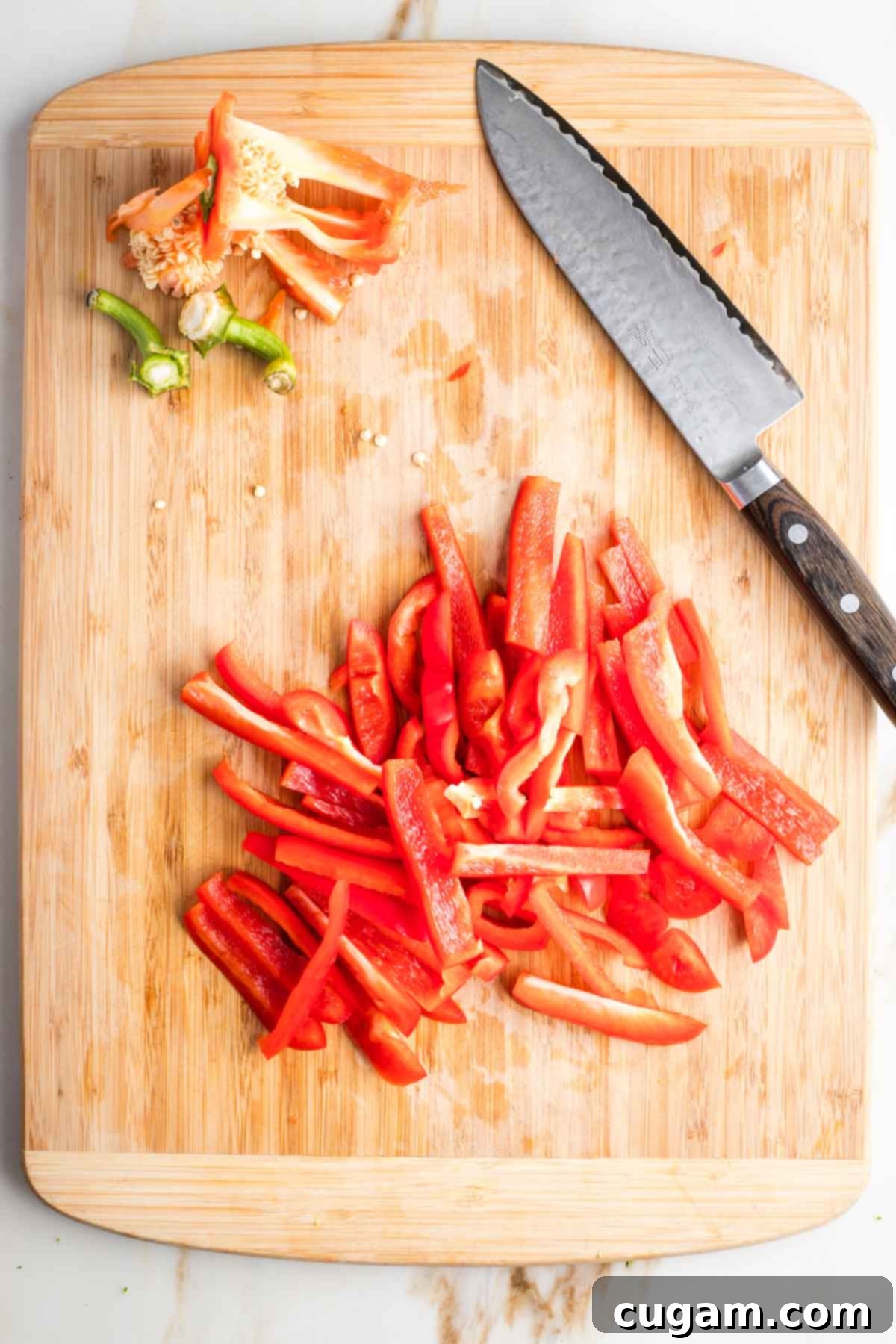 Strips of red pepper cut from two whole bell peppers.