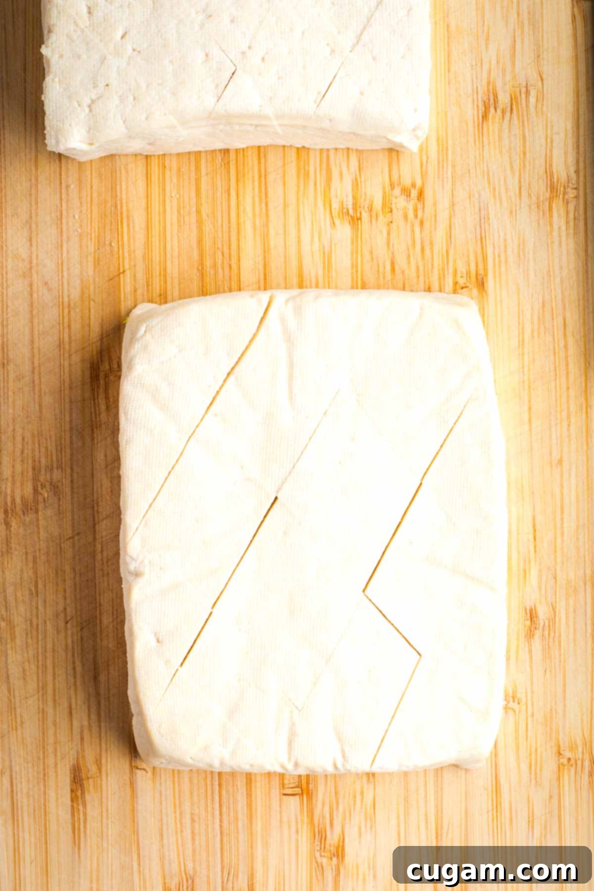 Block of tofu scored on the diagonal. 