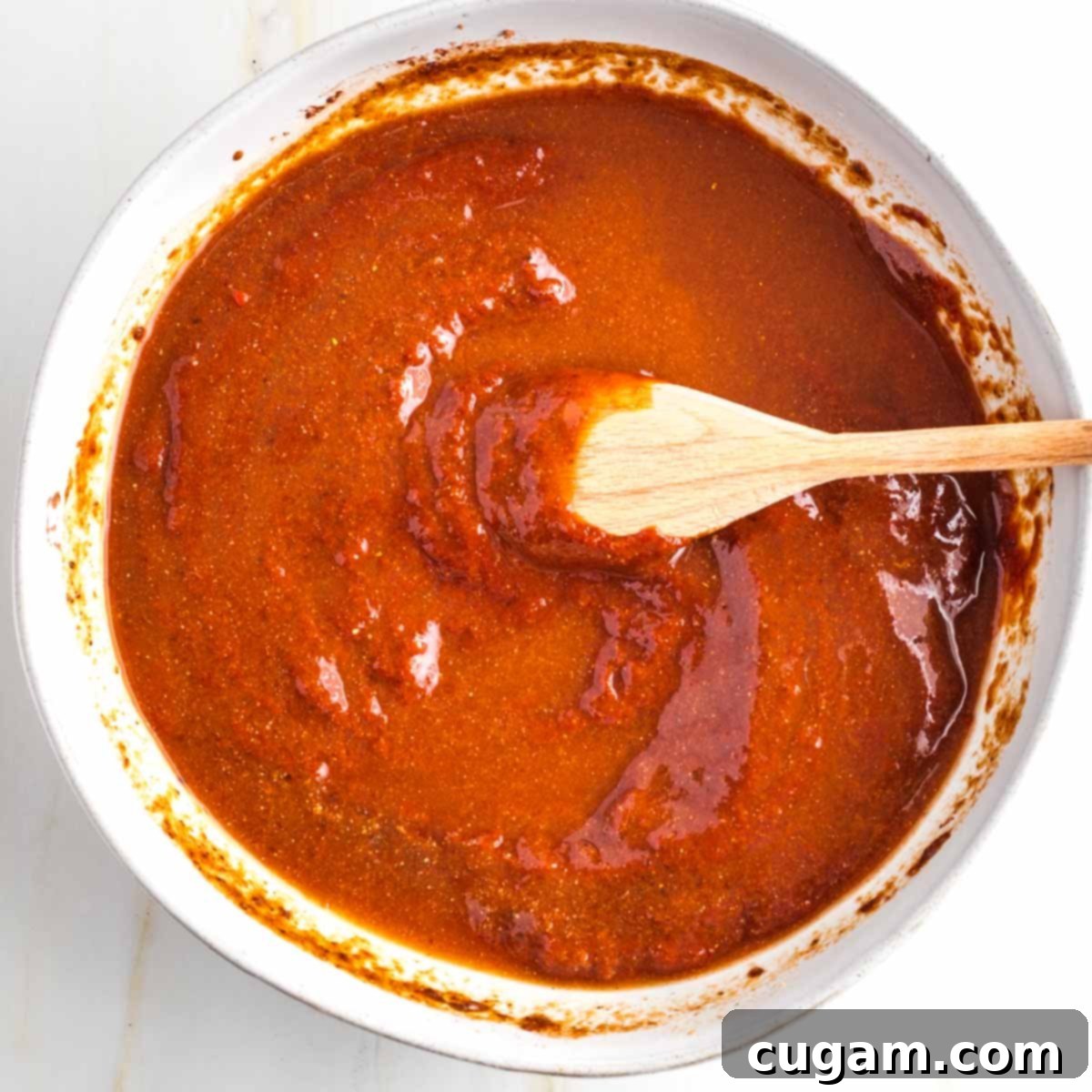 Stirring reddish brown pasty mixture to incorporate more liquick.