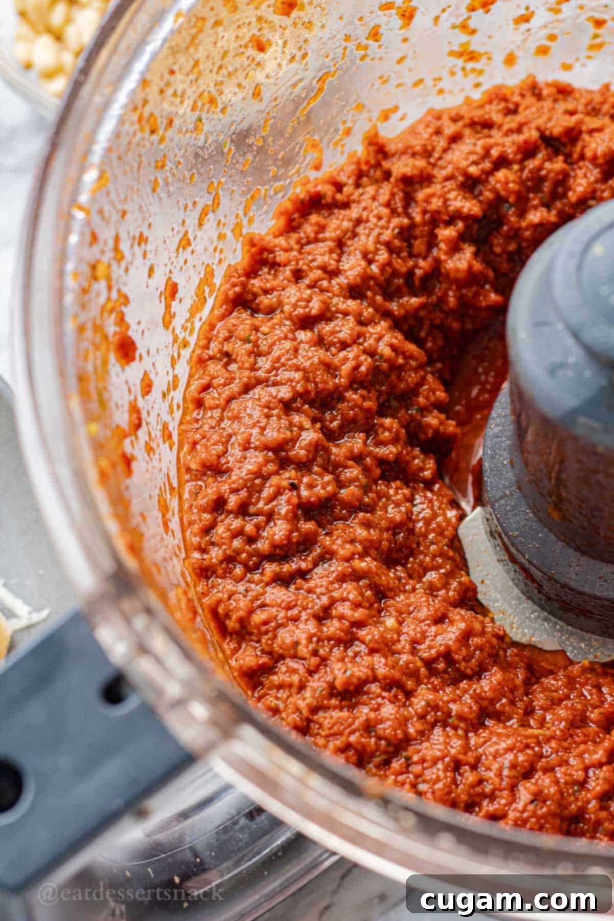 Blended red pesto in bowl of food processor.