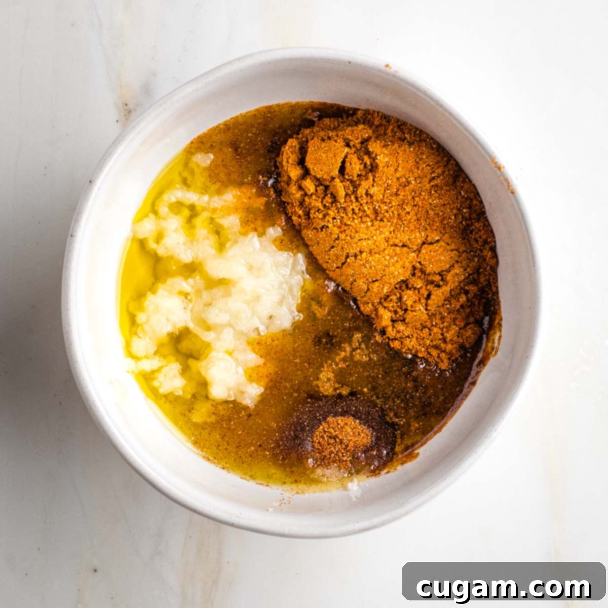 Small bowl with spices, oil, lemon and garlic.