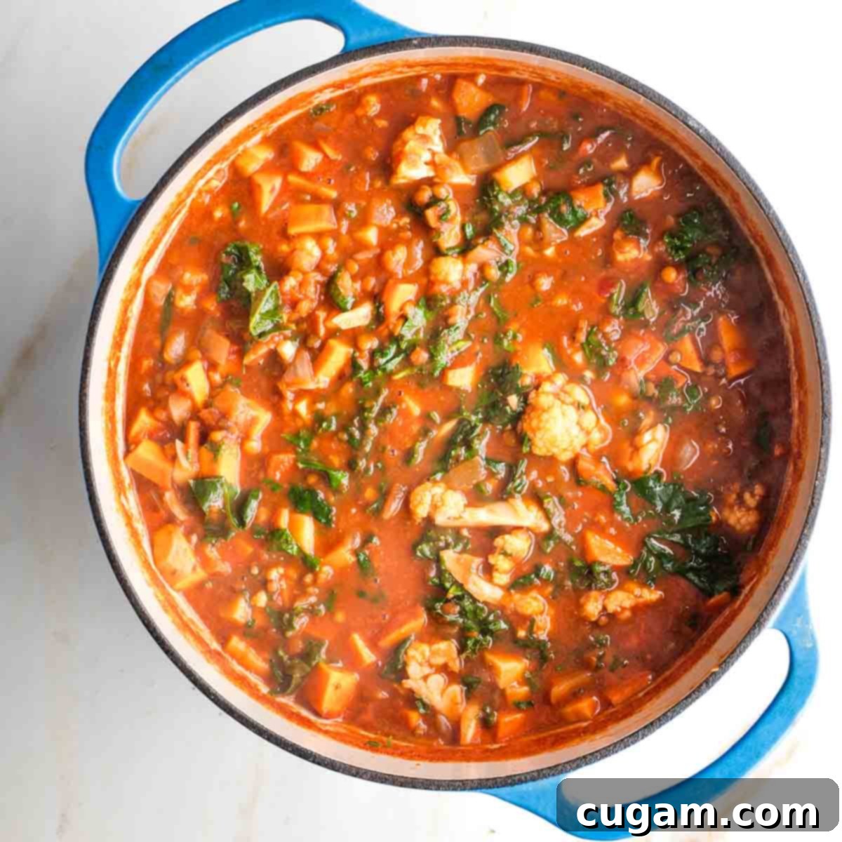 Wilted kale in a pot of chunky veggie stew.