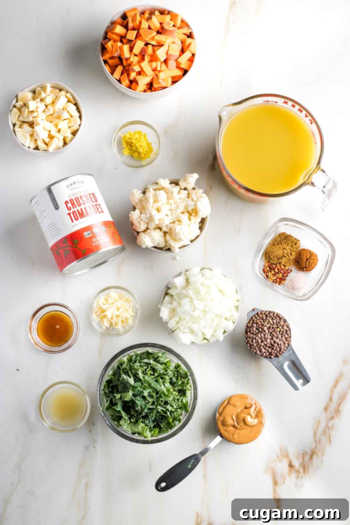 Chopped veggies in bowls, plus other ingredients laid out to make vegan peanut butter stew.