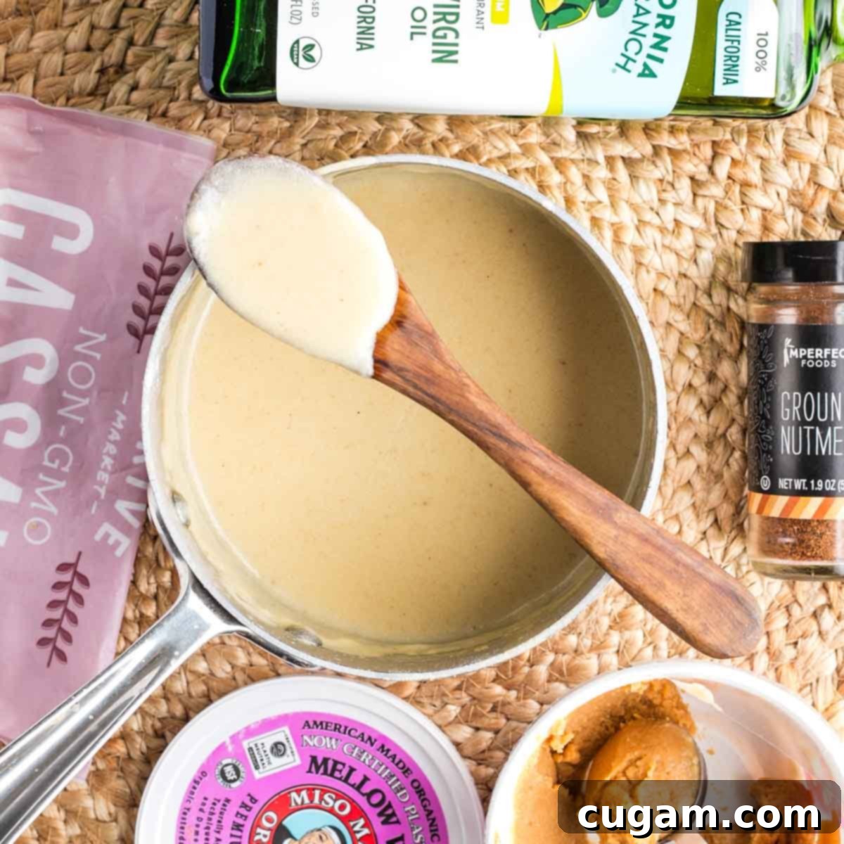 A wooden spoon showing off the perfect, creamy texture of the vegan bechamel sauce, a testament to Debra's expert tips.