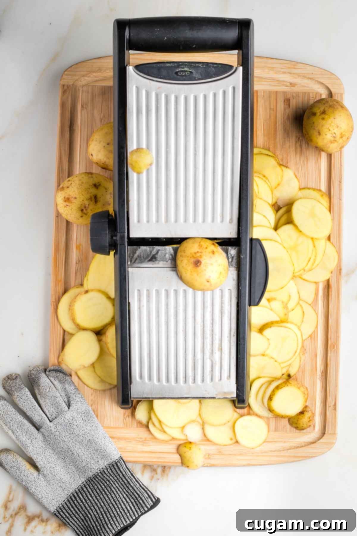 Mandolin slicing potatoes into ⅛" thickness. 