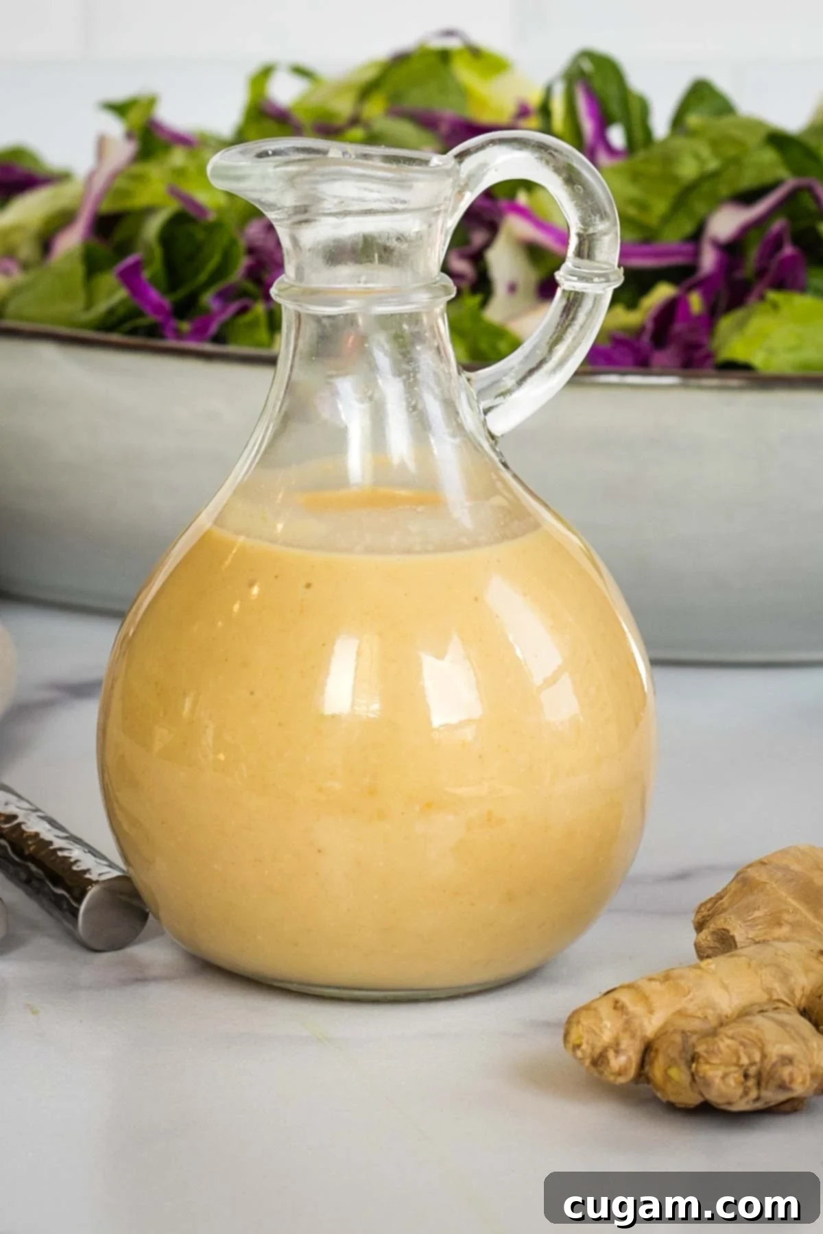 Effortless Ginger Miso Tahini Drizzle 2 Close up of a carafe of creamy ginger miso salad dressing, ready to be poured.