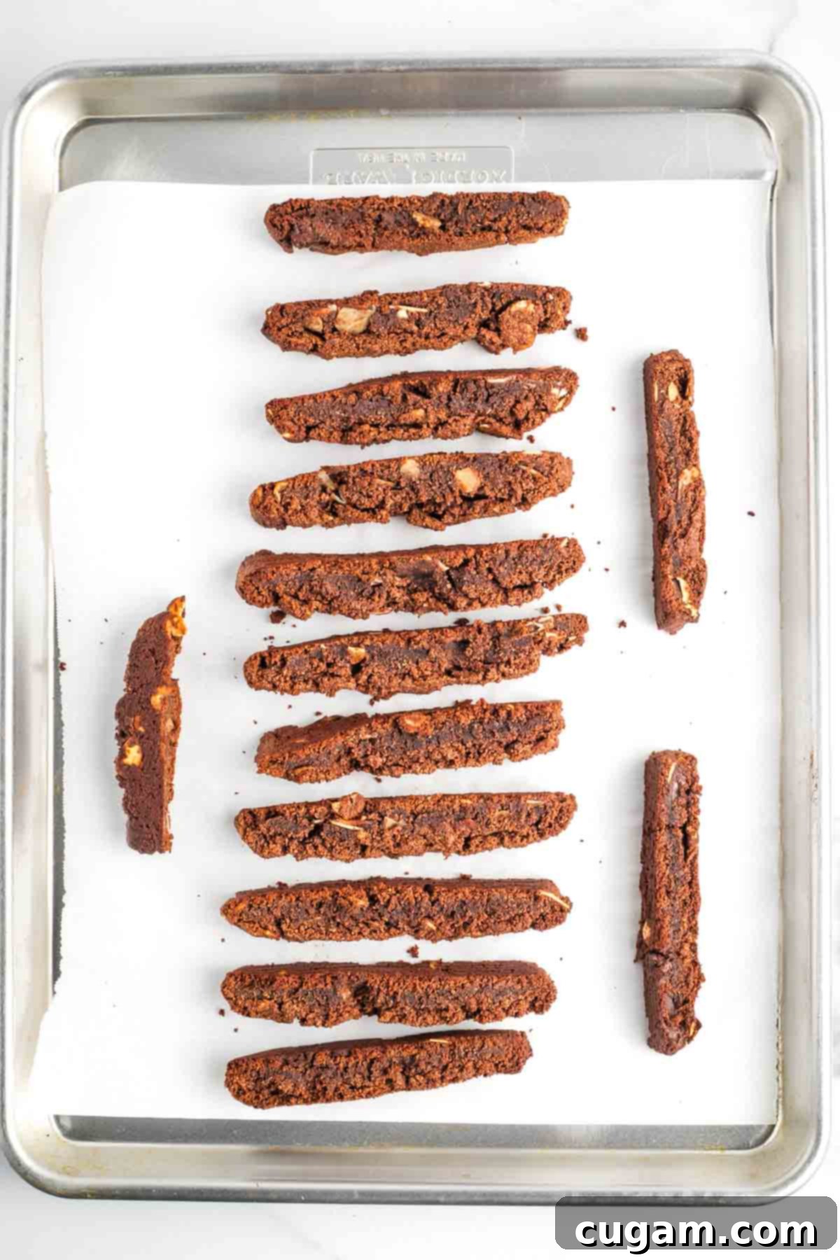Individual biscotti slices arranged on their sides on a baking sheet, ready for the second bake to achieve ultimate crunch.