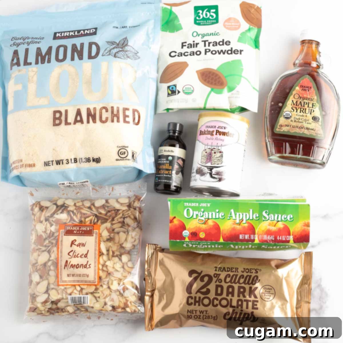 A beautifully arranged selection of the main ingredients: almond flour, cacao powder, sliced almonds, and applesauce, ready for baking.