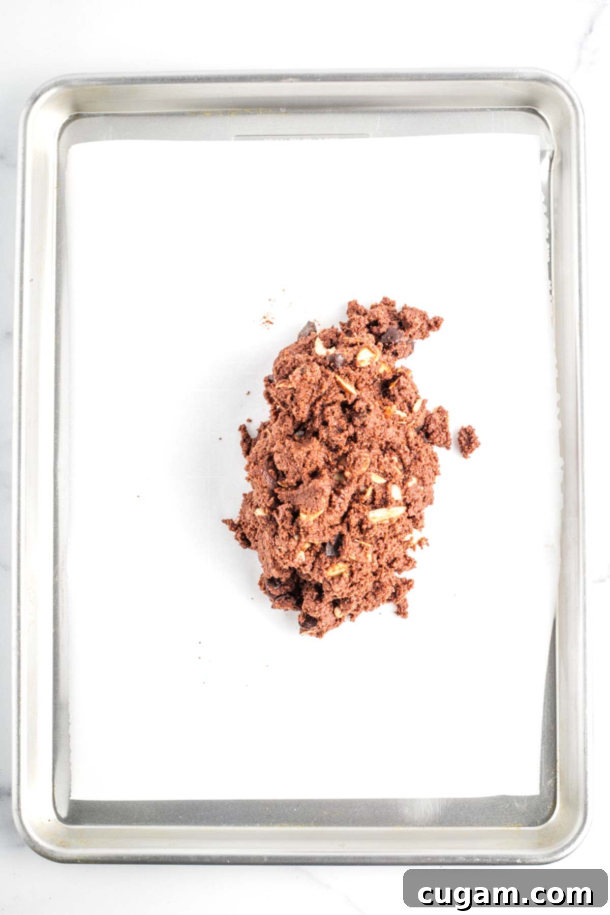 The chocolate biscotti batter expertly turned out onto a parchment-lined baking tray, ready for shaping.