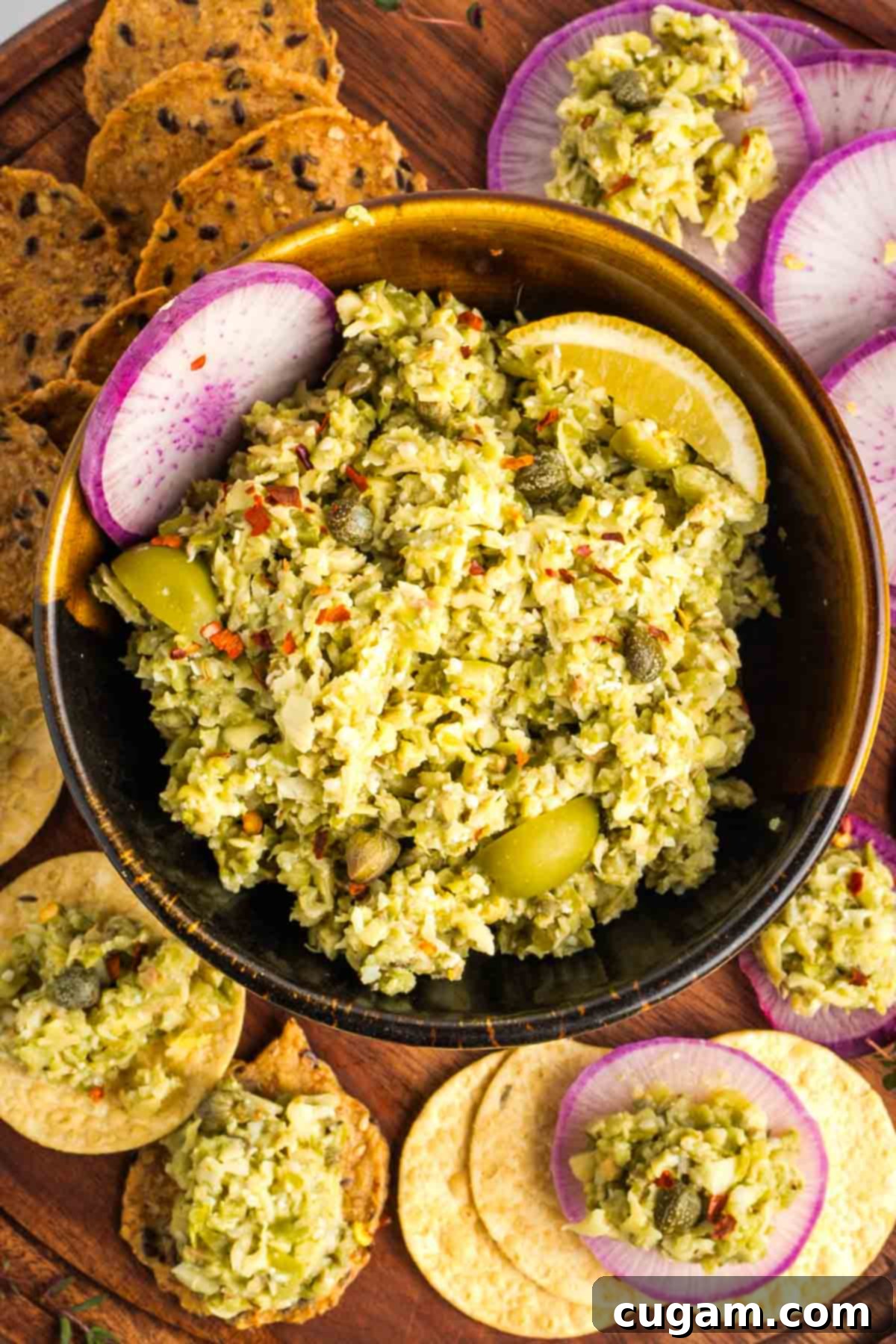 Artichokes, olives and capers blended into a chunky dip, spread onto crackers and radish slices.