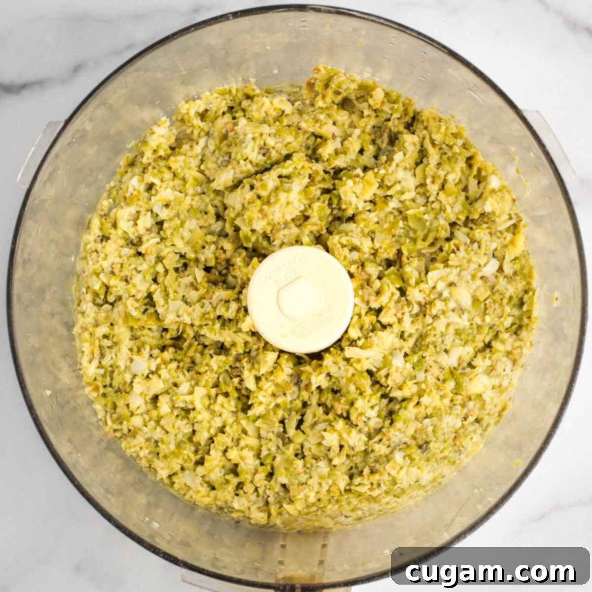 Chunky olive tapenade in the bowl of a food processor. 