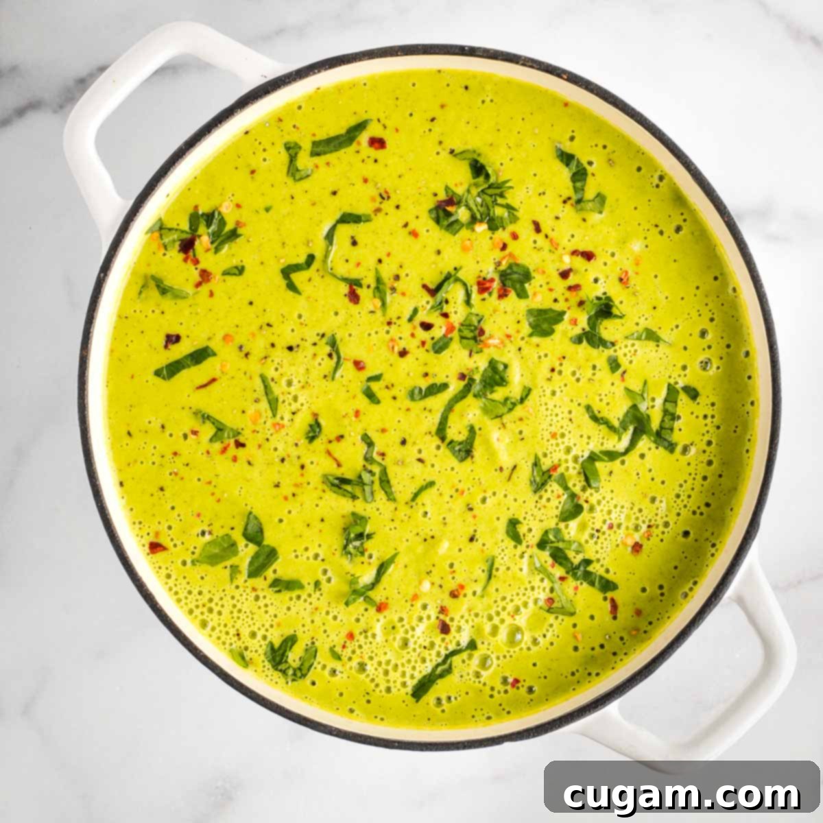 Pureed vegetable soup sprinkled with fresh herbs and crushed red pepper.