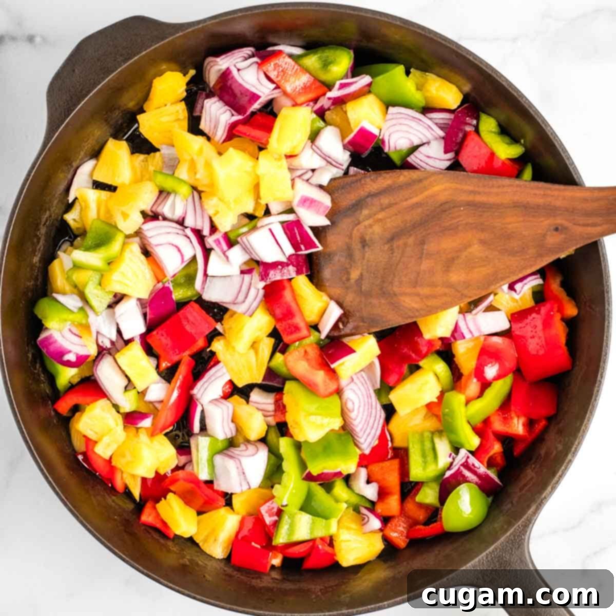 Sticky Sweet and Sour Crispy Tofu 11 Stir-frying bell peppers, onions, and pineapple chunks in a hot skillet.