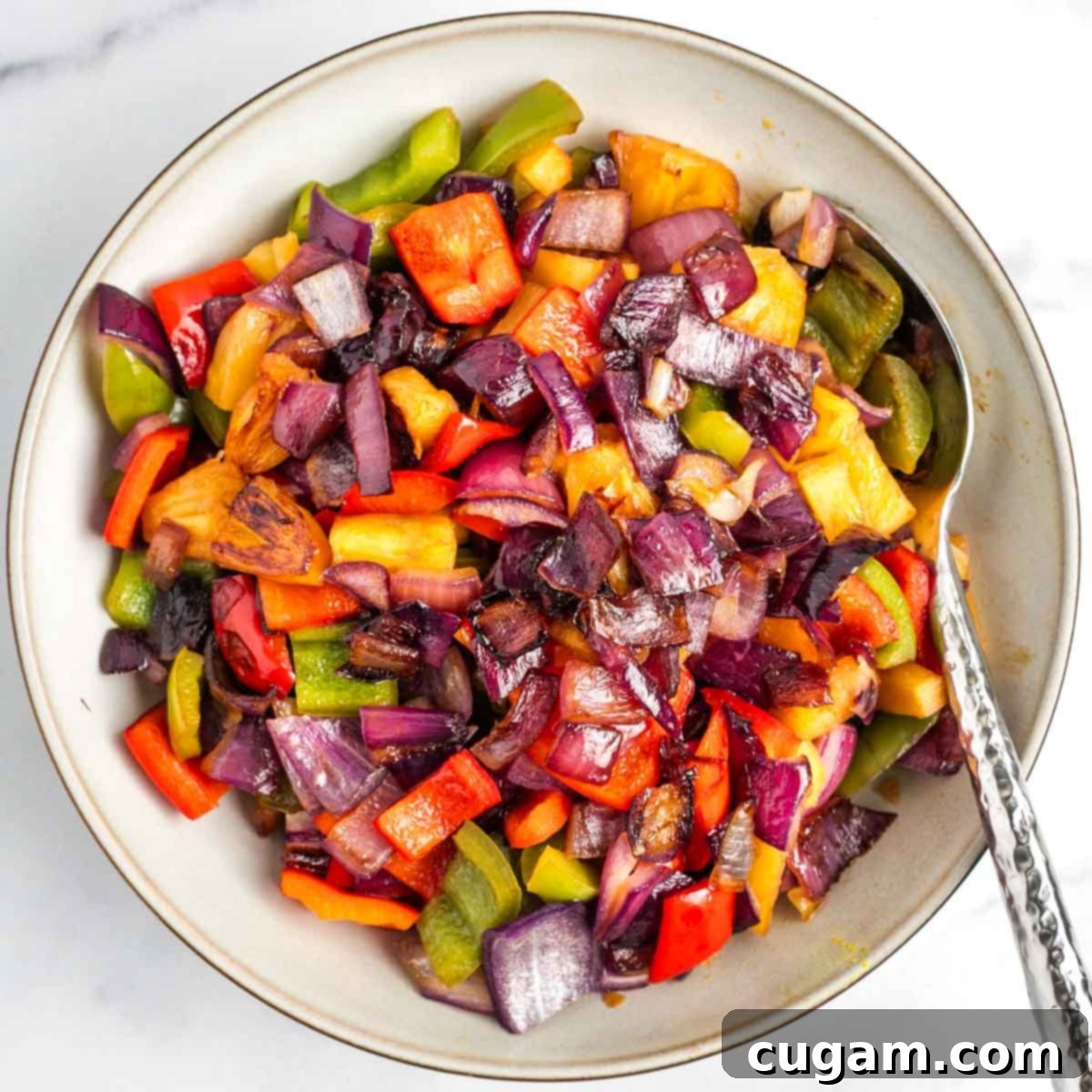 Sticky Sweet and Sour Crispy Tofu 12 Cooked vegetables and pineapple chunks transferred from skillet to a bowl.