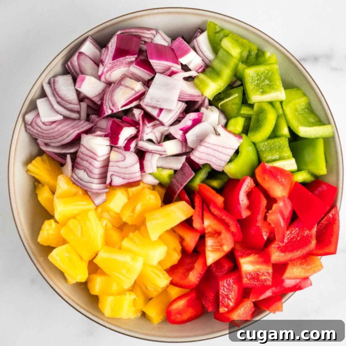 Sticky Sweet and Sour Crispy Tofu 6 Bowl with sections of chopped red onion, green peppers, red peppers and pineapple chunks ready for cooking.