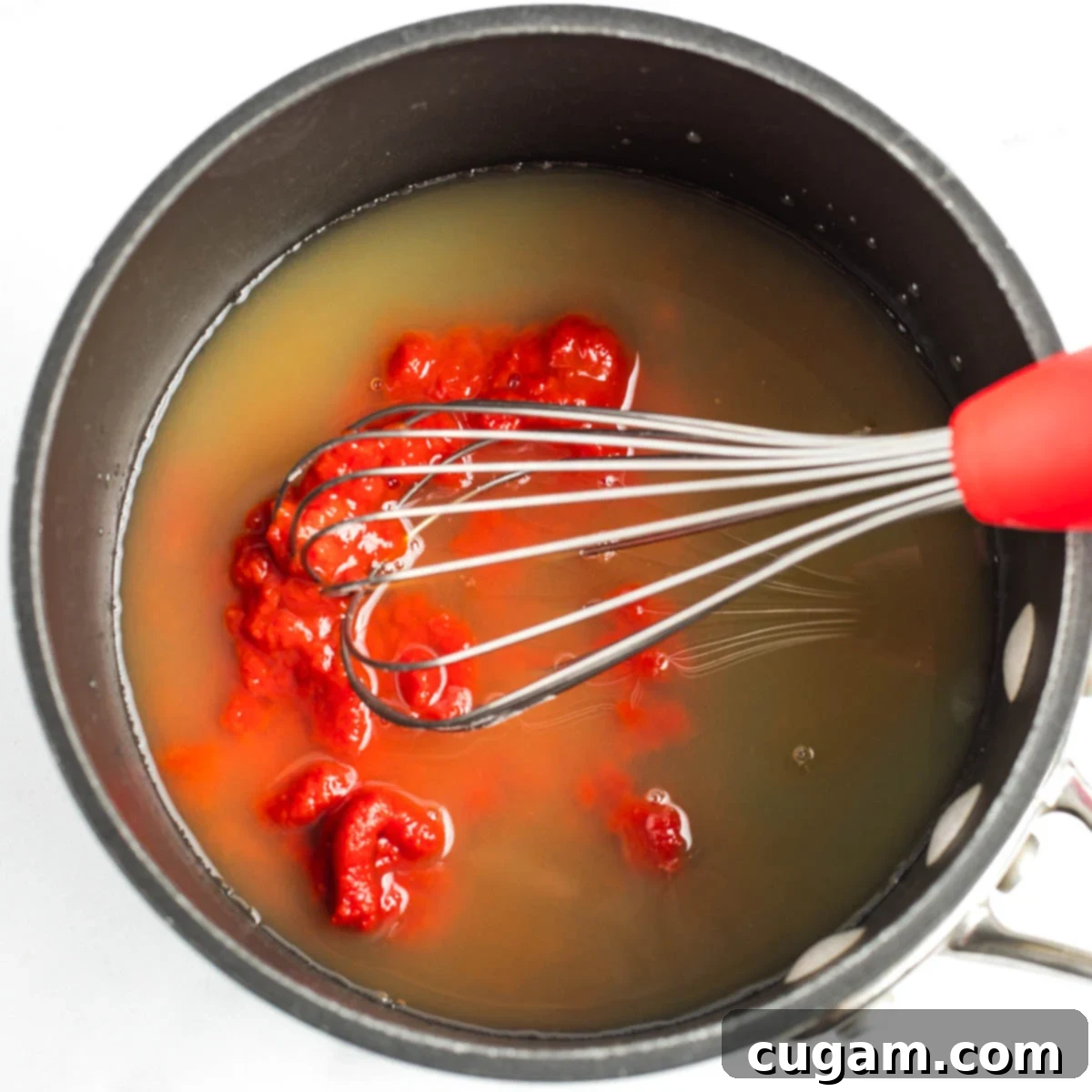 Sticky Sweet and Sour Crispy Tofu 7 Whisking tomato paste into pineapple juice, vinegar and maple syrup in a saucepan.