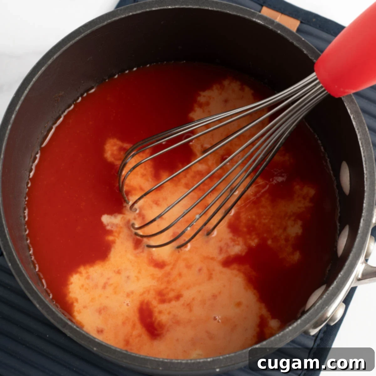 Sticky Sweet and Sour Crispy Tofu 9 Pouring the arrowroot slurry into the simmering sweet and sour sauce.