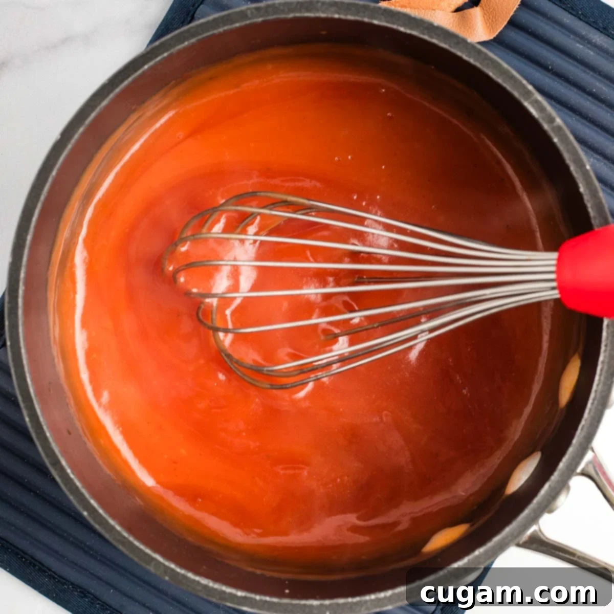 Sticky Sweet and Sour Crispy Tofu 10 Sweet and sour sauce thickening to a glossy consistency in the saucepan.