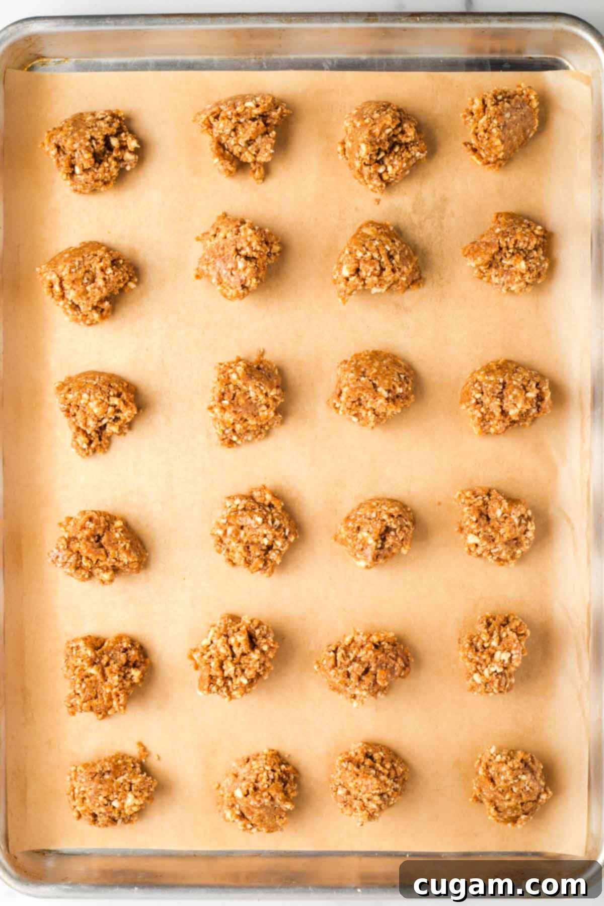 Decadent Vegan Almond Macaroons Enrobed in Chocolate 11 Two dozen almond cookies dropped onto a parchment lined baking tray.