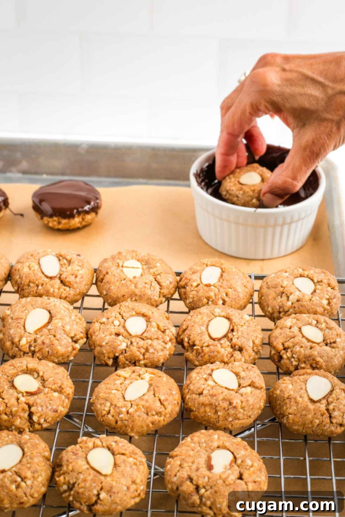 Decadent Vegan Almond Macaroons Enrobed in Chocolate 16 Dipping almond macaroon in melted chocolate.