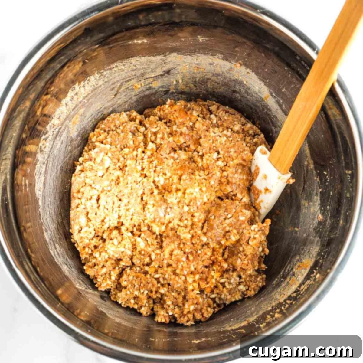 Nutty cookie dough batter with a uniform texture in a metal mixing bowl.