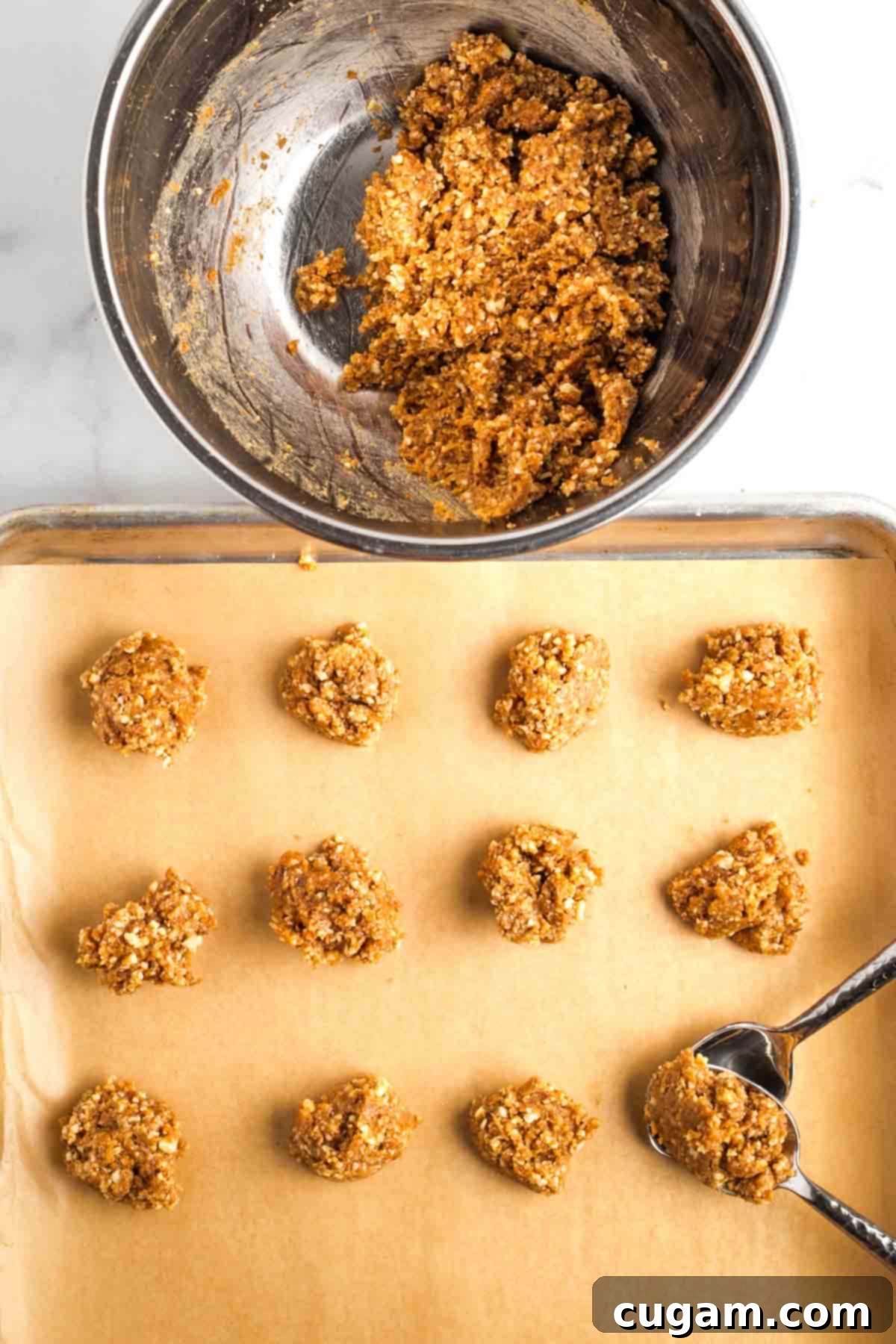 Decadent Vegan Almond Macaroons Enrobed in Chocolate 10 Using two spoons to scoop cookie dough from bowl, onto a parchment lined, rimmed baking sheet.
