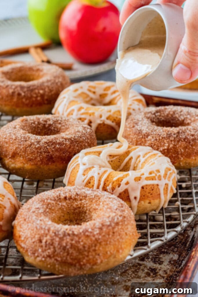 Drizzling icing over baked apple cider donut. 