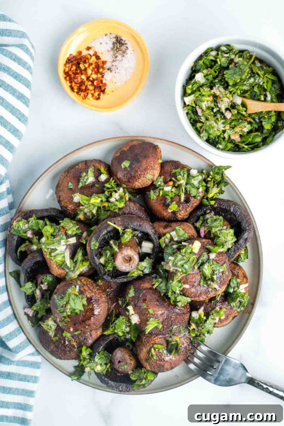 Bowl of roasted mushrooms with bright green chimichurri sauce, ready to be served.
