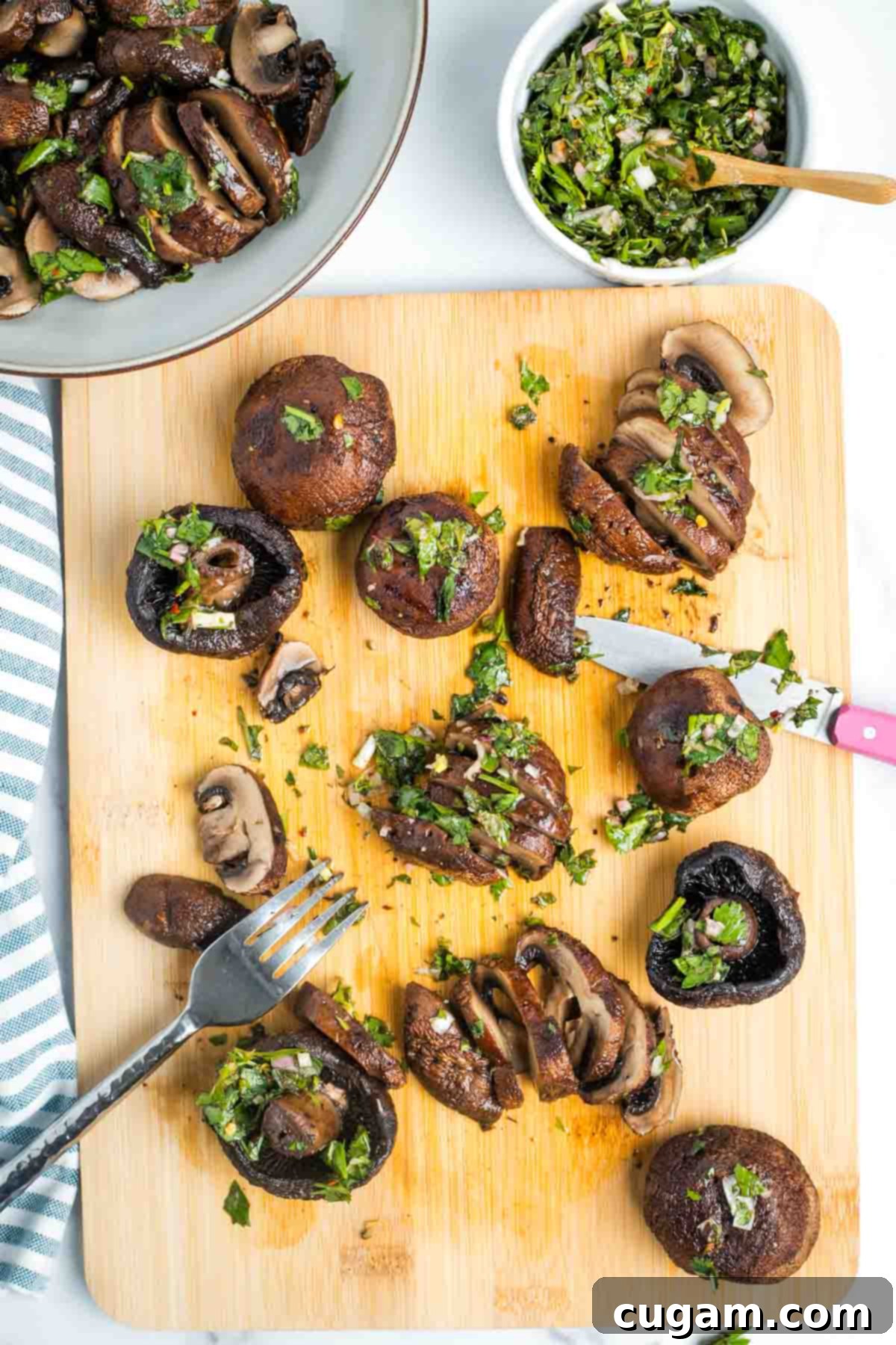 Slicing roasted portobello mushrooms on a cutting board, with a bowl of chimichurri nearby.