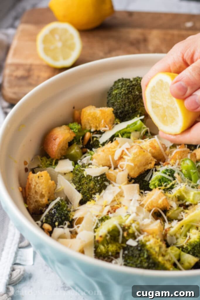 Squeezing lemon into blue bowl of roasted broccoli salad.