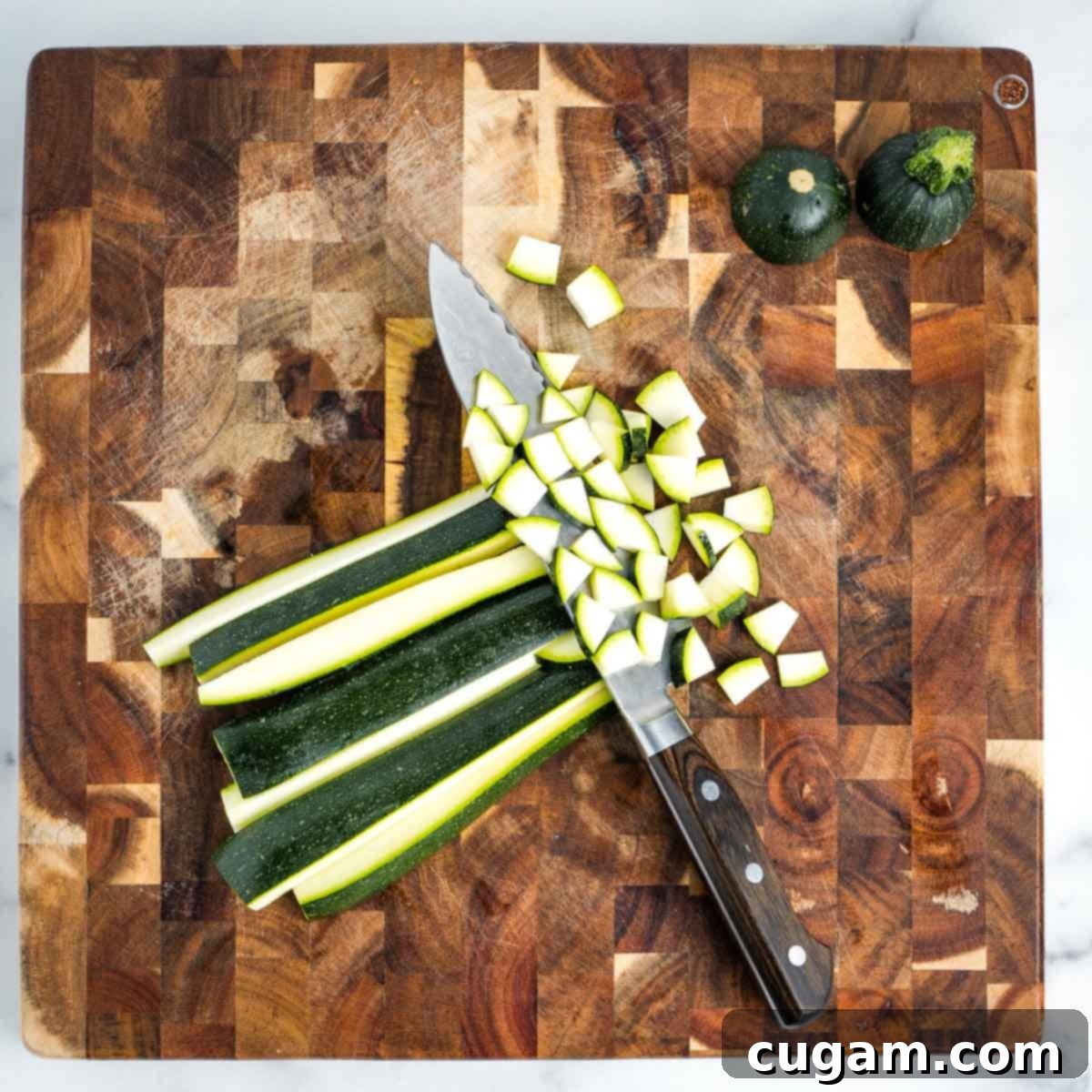 Effortless Vegan Potato and Veggie Skillet 7 Illustrating the process of dicing a zucchini into small cubes on a wooden cutting board.